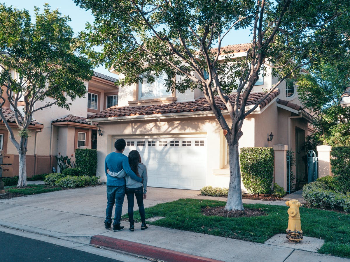 Veteran couple standing in front of new home